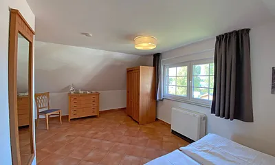 Schlafzimmer mit Doppelbett (1,80 m x 2,00 m), Nachtischablagen und Kleiderschrank 