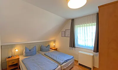 Schlafzimmer mit Doppelbett (1,80 m x 2,00 m), Nachttischablagen und Kleiderschrank