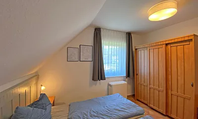 Schlafzimmer mit Doppelbett (1,80 m x 2,00 m), Nachttischablagen und Kleiderschrank