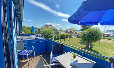 großer bestuhlter Balkon (West) mit Sonnenschirm und Panoramablick auf den Selliner See 