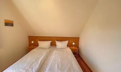 Schlafzimmer mit Doppelbett (1,80 m x 2,00 m), Nachttischablagen und Kleiderschrank 