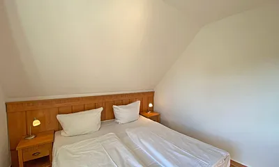 Schlafzimmer mit Doppelbett (1,80 m x 2,00 m), Nachttischablagen und Kleiderschrank 