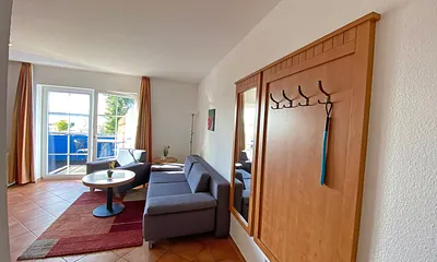 Wohnbereich mit Massivmöbeln, Stehlampe, Sessel und einer Schlafcouch (Aufbettung für 3./4. Person, 1,90 m x 1,40 m), Gesellschaftsspielen, 42 Zoll Smart-TV & Mini-Stereo-Anlage mit DAB Radio