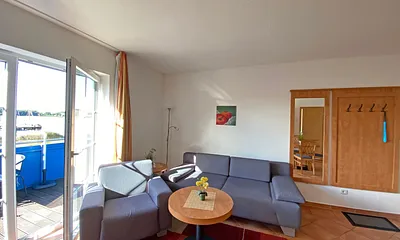 Wohnbereich mit Massivmöbeln, Stehlampe, Sessel und einer Schlafcouch (Aufbettung für 3./4. Person, 1,90 m x 1,40 m), Gesellschaftsspielen, 42 Zoll Smart-TV & Mini-Stereo-Anlage mit DAB Radio