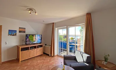 Wohnbereich mit Massivmöbeln, Stehlampe, Sessel und einer Schlafcouch (Aufbettung für 3./4. Person, 1,90 m x 1,40 m), Gesellschaftsspielen, 42 Zoll Smart-TV & Mini-Stereo-Anlage mit DAB Radio