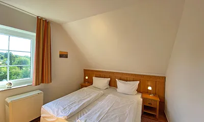 Schlafzimmer mit Doppelbett (1,80 m x 2,00 m), Nachttischablagen und Kleiderschrank 