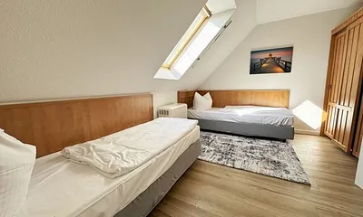 Schlafzimmer mit 2 Einzelbetten (0,90 m x 2,00 m), Nachttischablagen und Kleiderschrank 