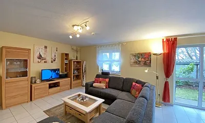 Wohn-/ Essbereich mit Essecke, gemütliche Couchecke (mit Ausziehfunktion 1,40m x 2,10m), Tisch, Anrichte, Leselampe, Flachbild-TV und Blu-Ray-Player