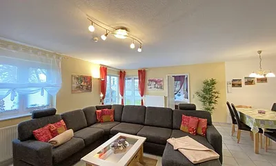 Wohn-/ Essbereich mit Essecke, gemütliche Couchecke (mit Ausziehfunktion 1,40m x 2,10m), Tisch, Anrichte, Leselampe, Flachbild-TV und Blu-Ray-Player