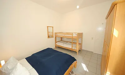 Schlafzimmer mit Doppelbett (1,60 m x 2,00 m), verstellbare Lattenroste, Nachtischkonsolen, Kleiderschrank und Etagenbett (0,90 m x 2,00 m)