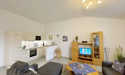 Wohnzimmer mit gemütlicher Couchecke (Ausziehfunktion 1,10 m x 2,00 m), Couchtisch, Leselampe, Anrichte, Flachbild-TV und Mini-Stereo-Anlage