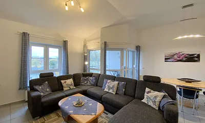 Wohnzimmer mit gemütlicher Couchecke (Ausziehfunktion 1,10 m x 2,00 m), Couchtisch, Leselampe, Anrichte, Flachbild-TV und Mini-Stereo-Anlage
