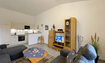 Wohnzimmer mit gemütlicher Couchecke (Ausziehfunktion 1,10 m x 2,00 m), Couchtisch, Leselampe, Anrichte, Flachbild-TV und Mini-Stereo-Anlage