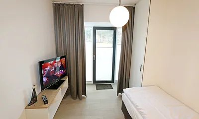 Schlafzimmer mit einem Einzelbett (0,90 m x 2,00 m), Nachttischablage mit Beleuchtung und USB Anschlüssen sowie einem Kleiderschrank