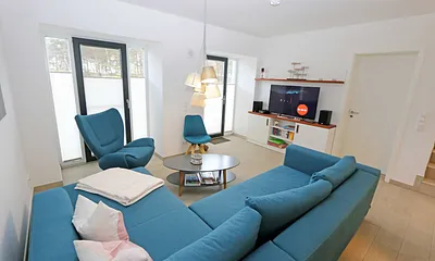 Wohnzimmer mit komfortabler Eckcouch, Couchtisch, Sideboard, Smart-TV sowie eine Mini-Stereo-Anlage mit Bluetooth und USB-Anschluss