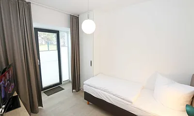 Schlafzimmer mit einem Einzelbett (0,90 m x 2,00 m), Nachttischablage mit Beleuchtung und USB Anschlüssen sowie einem Kleiderschrank