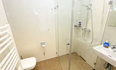 Bäder mit jeweils einem WC, ebenerdiger Dusche, Kosmetikspiegel, Fön, Handtuchtrockner sowie einem Waschplatz mit großzügigem Spiegel und Ablagefläche