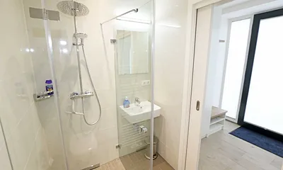 Bäder mit jeweils einem WC, ebenerdiger Dusche, Kosmetikspiegel, Fön, Handtuchtrockner sowie einem Waschplatz mit großzügigem Spiegel und Ablagefläche