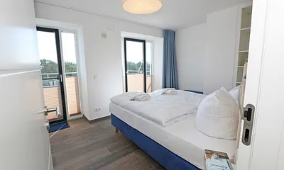 Schlafzimmer mit Boxspringbetten ( Doppelbett 1,60 m x 2,00 m ), Smart-TV, Nachttischablagen mit Beleuchtung und USB-Anschlüssen sowie Kleiderschränken