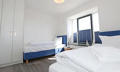 Schlafzimmer mit Boxspringbetten ( Einzelbetten je 0,90 m x 2,00 m ), Smart-TV, Nachttischablagen mit Beleuchtung und USB-Anschlüssen sowie Kleiderschränken