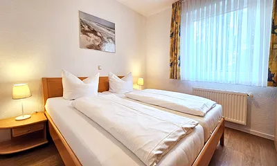 Schlafzimmer mit Doppelbett & Kleiderschrank (Verdunklungsjalousie vor dem Fenster)