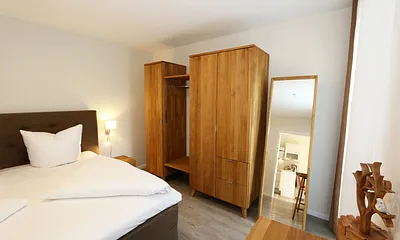 Schlafzimmer ist mit einem Boxspringbett (1,80 m x 2,00 m), durchgehenden Topper, Nachttischablagen, Kosmetiktisch, Kleiderablage sowie einen Kleiderschrank