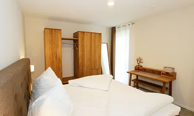 Schlafzimmer ist mit einem Boxspringbett (1,80 m x 2,00 m), durchgehenden Topper, Nachttischablagen, Kosmetiktisch, Kleiderablage sowie einen Kleiderschrank