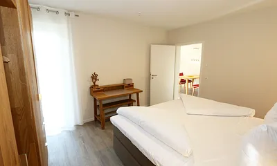 Schlafzimmer ist mit einem Boxspringbett (1,80 m x 2,00 m), durchgehenden Topper, Nachttischablagen, Kosmetiktisch, Kleiderablage sowie einen Kleiderschrank