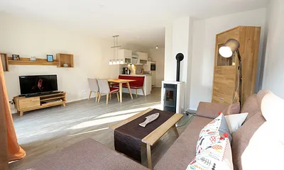 Wohn-/Küchenbereich mit hochwertigen Massivholzmöbeln, Couch ( Aufbettung für 3. Person 0,90 m x 2,00 m), Couchtisch, Leselampe, Kamin Pelletofen, TV-Board mit Smart-TV sowie eine Bose Soundbar