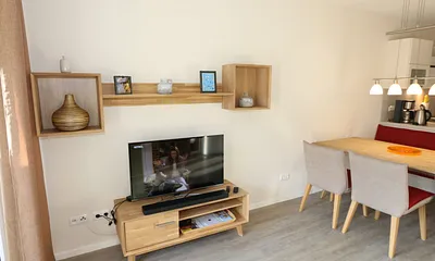 offener Wohn-/Küchenbereich mit hochwertigen Massivholzmöbeln, Couch ( Aufbettung für 3. Person 0,90 m x 2,00 m), Couchtisch, Leselampe, Kamin Pelletofen, TV-Board mit Smart-TV und eine Bose Soundbar