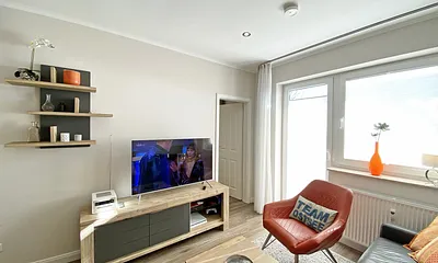 Wohnzimmer mit Stuhl und TV