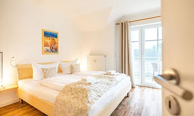 Schlafzimmer mit Doppelbett und angrenzendem Balkon