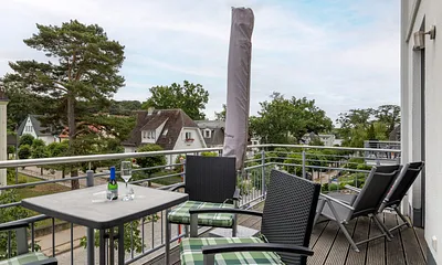 Der bequem möblierte Balkon mit einem Strandkorb statt Sonnenliegen.
