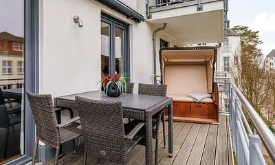 Der bequem möblierte Balkon mit einem Strandkorb statt Sonnenliegen.