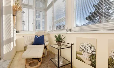 Der verglaste Südbalkon mit Relaxsessel.