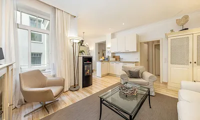 Der Blick zur Küchenzeile mit Geschirrspüler, 4-Platten-Cerankochfeld und Kühlschrank mit Eisfach.