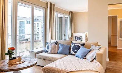 Auf der Couch kann aufgebettet werden. Im Hintergrund der Austritt zum Balkon.