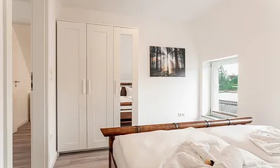 Schlafzimmer mit Doppelbett und Kleiderschrank