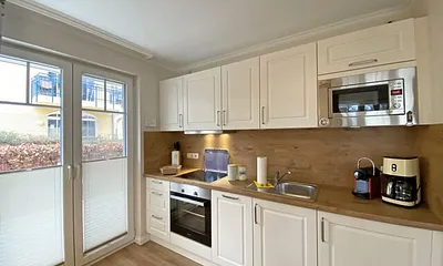 offene Küchenzeile mit Kühlschrank und Gefrierfach, Geschirrspüler, 4 Zonen Ceranfeld, Backofen, Mikrowelle, Kaffeemaschine, Nespresso Kapsel-Maschine, Toaster und Wasserkocher 