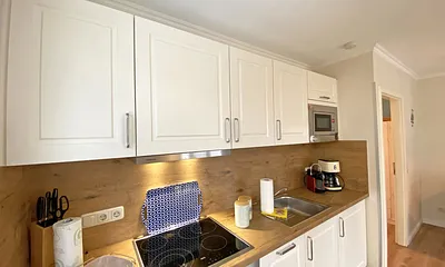 offene Küchenzeile mit Kühlschrank und Gefrierfach, Geschirrspüler, 4 Zonen Ceranfeld, Backofen, Mikrowelle, Kaffeemaschine, Nespresso Kapsel-Maschine, Toaster und Wasserkocher