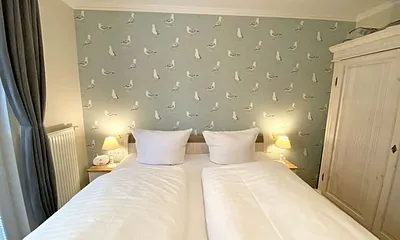 Schlafzimmer mit Doppelbett in Komforthöhe (1,80 m x 2,00 m), verstellbare Lattenroste, Nachtischablagen mit Lampen sowie ein zweitüriger Kleiderschrank