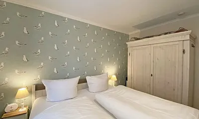 Schlafzimmer mit Doppelbett in Komforthöhe (1,80 m x 2,00 m), verstellbare Lattenroste, Nachtischablagen mit Lampen sowie ein zweitüriger Kleiderschrank