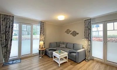 Wohnbereich mit gemütlicher Couch (Aufbettung für die 3. Person, Liegefläche 1,60 m x 2,00 m), Couchtisch, Leselampe, Lowbord mit Smart-TV, DAB-Radio mit USB-Anschluss sowie Bluetooth Anschluss