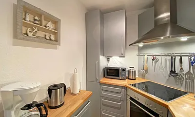 separate Küche mit Spülmaschine, Kühlschrank mit Eisfach, Mikrowelle, Ceranfeld mit Backofen, Wasserkocher, Kaffeemaschine, Senseo Padmaschine, Toaster und diversen Küchenutensilien