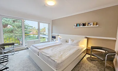 Schlafzimmer mit Doppelbett und Blick ins Grüne