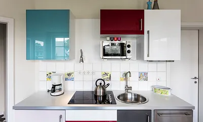 Die Küchenzeile mit Geschirrspüler und Mikrowelle.