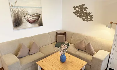 Wohnbereich mit Eckcouch (Aufbettung für die 3. Person, 1,20 m x 1,95 m), Couchtisch, Stehlampe, Vitrine sowie ein Sideboard mit Flachbild-TV