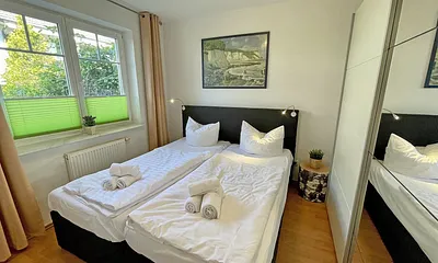 Schlafzimmer mit Doppelbett (1,80 m x 2,00 m), Nachttischablagen und einen Kleiderschrank