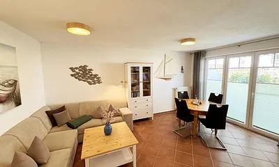 Wohnbereich mit Eckcouch (Aufbettung für die 3. Person, 1,20 m x 1,95 m), Couchtisch, Stehlampe, Vitrine sowie ein Sideboard mit Flachbild-TV