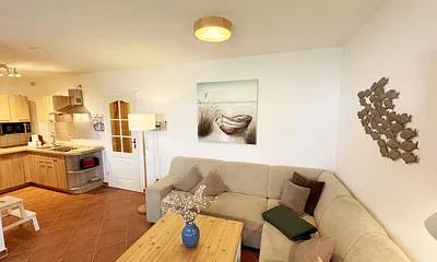 Wohnbereich mit Eckcouch (Aufbettung für die 3. Person, 1,20 m x 1,95 m), Couchtisch, Stehlampe, Vitrine sowie ein Sideboard mit Flachbild-TV